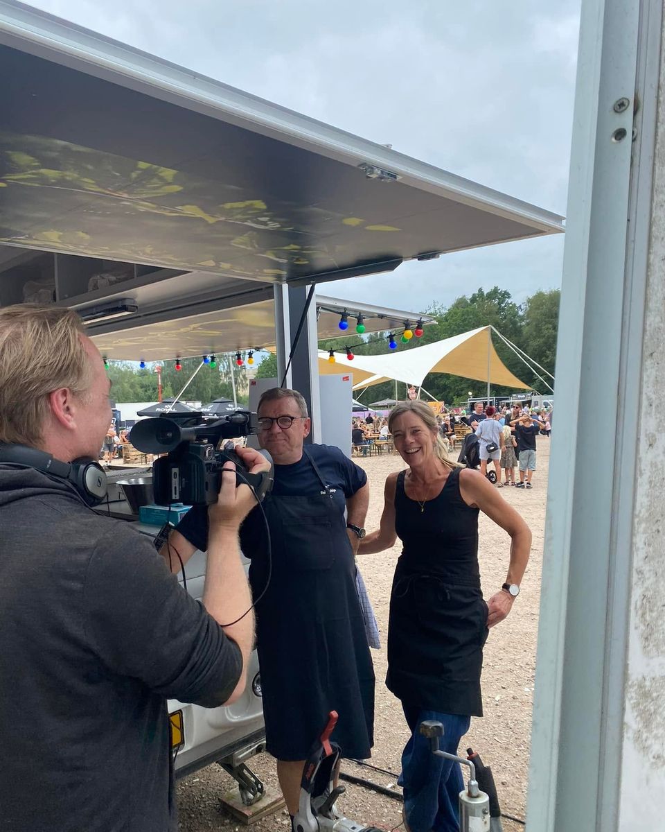 Et tv-hold filmer holdet bag vognen ved en festival