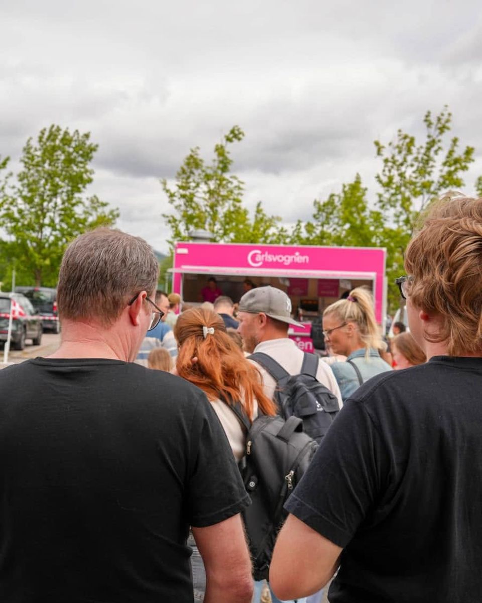 Gæster på vej hen mod Carlsvognen ved et udendørs arrangement