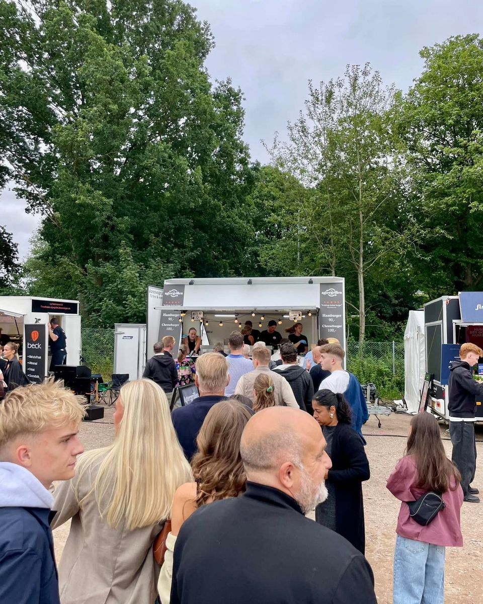 Lang kø af gæster foran Agtergrillens vogn ved en festival